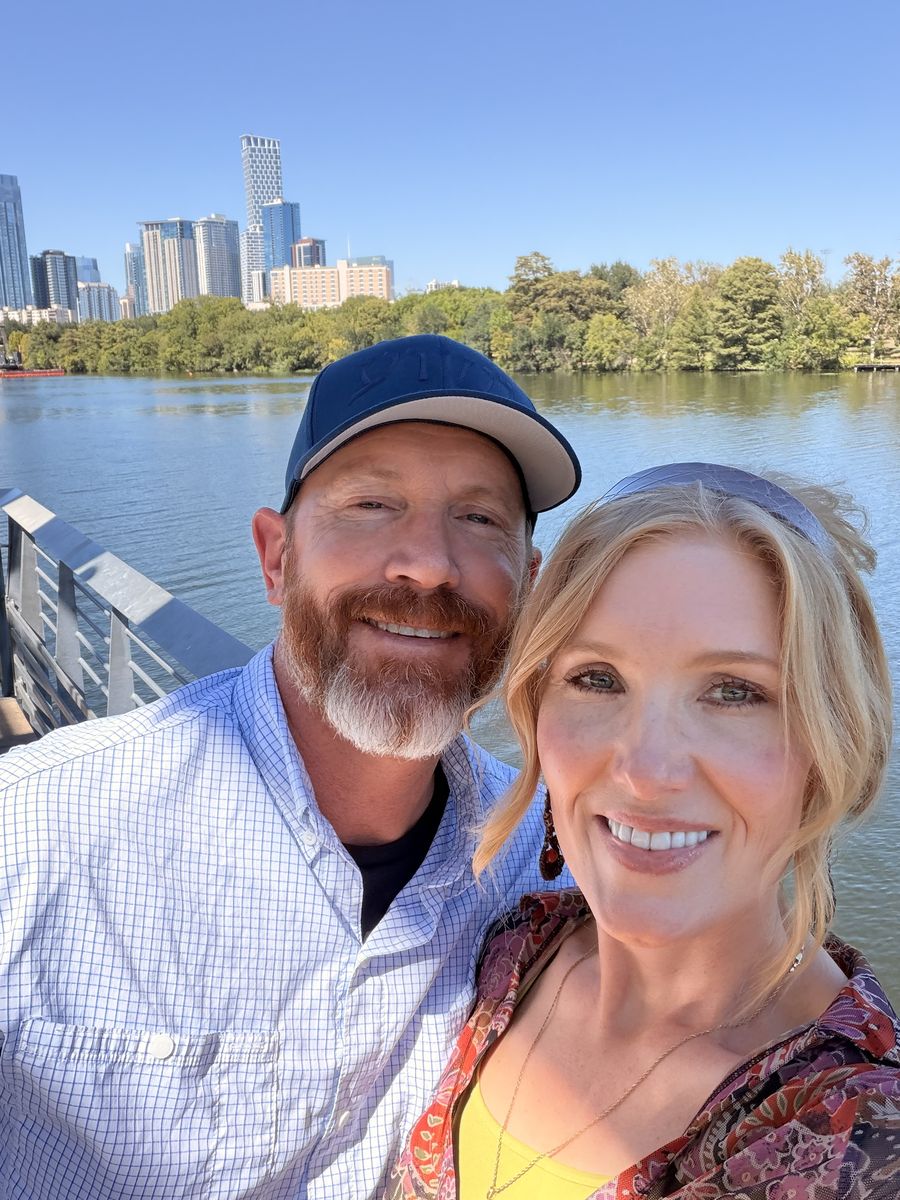 Tabitha and Kevin Lovell smiling on Lady Bird Lake in Austin, Texas, with the downtown skyline behind them
